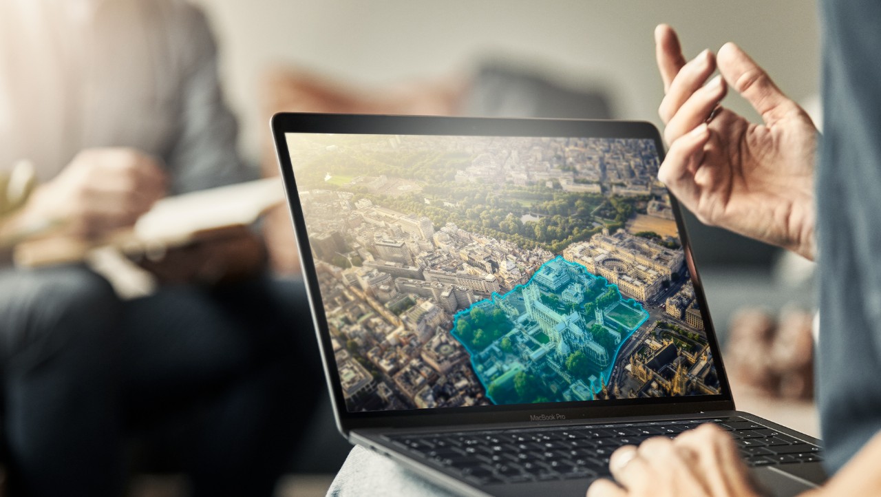 Image of a laptop open on someone's lap and a hand on the keyboard operating it